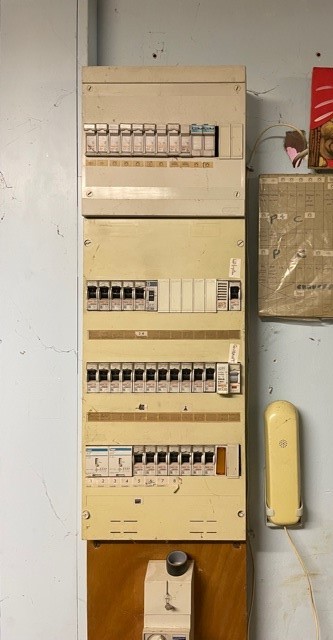 Ancien tableau électrique jauni quatre rangées sur planche avant mise aux normes à Wicres