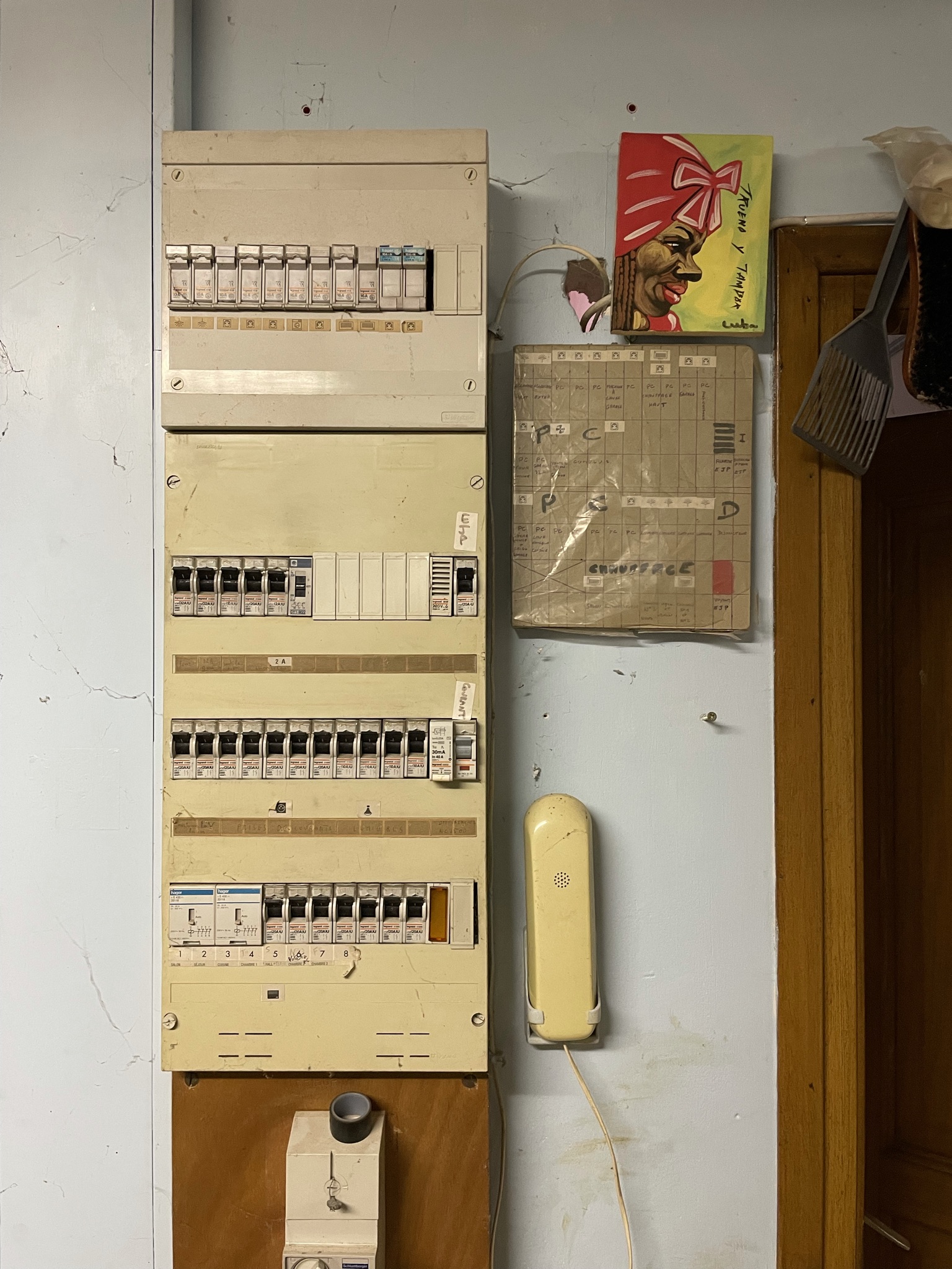 Ancien coffret électrique crème sur planche de bois avant mise en sécurité électrique à Salomé